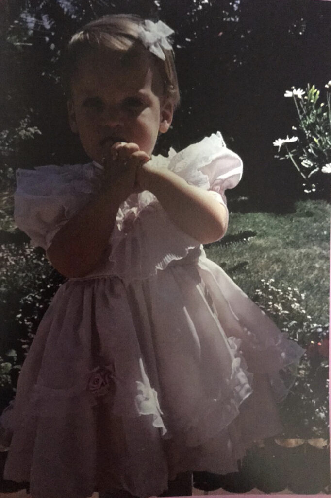 Ein blondes Mädchen im rosa Kleid.